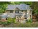 Rear exterior of a two-story home featuring a stone patio and lush landscaping at 525 Watergate Ct, Roswell, GA 30076