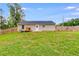 Backyard with wooden fence, grassy lawn, small deck, and a dog house next to the house at 159 Cranbrooke Dr, Dallas, GA 30157