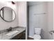Bathroom featuring granite countertop vanity, modern fixtures, and a round mirror at 159 Cranbrooke Dr, Dallas, GA 30157