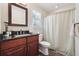Bathroom featuring dark granite countertops, a dark vanity, and shower-tub with shower curtain at 2460 Due West Nw Cir, Kennesaw, GA 30152