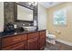 Stylish bathroom featuring a vessel sink, decorative backsplash, and black granite countertop at 2460 Due West Nw Cir, Kennesaw, GA 30152