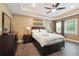 Comfortable bedroom with wooden floors, tray ceiling and fan, a dresser and large windows at 2460 Due West Nw Cir, Kennesaw, GA 30152