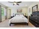 Well-lit bedroom with ceiling fan, soft carpet, and a large dark dresser at 2460 Due West Nw Cir, Kennesaw, GA 30152