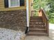 Exterior view of a staircase leading up to the home, with stone accents and black shutters on the windows at 2460 Due West Nw Cir, Kennesaw, GA 30152