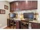 This home office boasts custom cabinets, granite countertops and tiled backsplash, providing ample space for work at 2460 Due West Nw Cir, Kennesaw, GA 30152