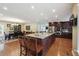 Bright, open kitchen and dining area featuring a large kitchen island with barstool seating, stainless appliances, and hardwood floors at 2460 Due West Nw Cir, Kennesaw, GA 30152