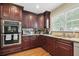 Well-equipped kitchen featuring stainless steel appliances, granite countertops, tiled backsplash, and beautiful wood cabinetry at 2460 Due West Nw Cir, Kennesaw, GA 30152