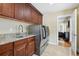 Functional laundry room with granite countertops, cabinets, stainless steel washer and dryer and a sink at 2460 Due West Nw Cir, Kennesaw, GA 30152