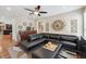 Spacious living room featuring a stylish leather sectional, decorative wall art, and hardwood floors at 2460 Due West Nw Cir, Kennesaw, GA 30152