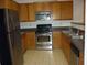 Kitchen featuring stainless steel appliances, wood cabinets, and neutral tile floors at 2502 Walden Lake Dr, Decatur, GA 30035