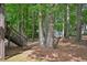 Natural backyard with mature trees and a small storage shed, plus a wooden deck with stairs at 4035 Woodbridge Ct, Powder Springs, GA 30127