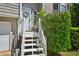Close-up of the entryway with a decorated front door, white stairs, and lush landscaping at 4035 Woodbridge Ct, Powder Springs, GA 30127