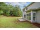 Home's backyard featuring a patio, lush lawn, and trees, providing a serene outdoor space at 463 The Gables Dr, Mcdonough, GA 30253