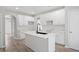 Modern kitchen featuring white cabinets, an island with a black faucet, and new floors at 463 The Gables Dr, Mcdonough, GA 30253
