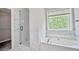 Bright main bathroom features a soaking tub, glass enclosed shower, and a large window at 463 The Gables Dr, Mcdonough, GA 30253