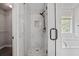 Glass enclosed shower with black hardware features marble style tile and a shower niche at 463 The Gables Dr, Mcdonough, GA 30253