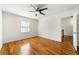 Bright bedroom features a ceiling fan, hardwood floors, and a view of the backyard through the window at 1622 Executive Park Ne Ln, Atlanta, GA 30329