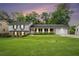 Charming home at dusk with a brick and white facade, and a well-manicured lawn at 2855 Cedar Canyon Ct, Atlanta, GA 30345