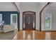 Grand foyer with wood flooring, a decorative front door, and arched doorways at 3305 Millwater Xing, Dacula, GA 30019