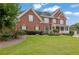 Beautiful two-story brick home with a lush green lawn and a variety of flowering bushes at 3305 Millwater Xing, Dacula, GA 30019