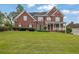 Charming two-story brick home with a well-manicured lawn, covered porch, and black shutters at 3305 Millwater Xing, Dacula, GA 30019