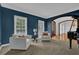 Comfortable sitting area with blue accent wall, white chairs, and elegant table lamp at 3305 Millwater Xing, Dacula, GA 30019