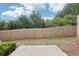 Fenced backyard with trees, a concrete patio, and lush greenery providing a private outdoor space at 607 Tall Timbers, Woodstock, GA 30188