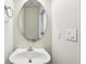 Bathroom featuring a single sink vanity, oval mirror, and light fixtures with light switches on the wall at 607 Tall Timbers, Woodstock, GA 30188