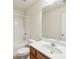 Bathroom featuring a white vanity, mirror, toilet, and shower-tub combo with white tile surround at 607 Tall Timbers, Woodstock, GA 30188