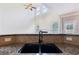 Close-up of the kitchen sink with granite countertops and tile backsplash, with an open living space behind at 607 Tall Timbers, Woodstock, GA 30188