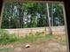 Framed backyard view shows a wooden fence, lush trees, and green grass, captured through the window frame at 1406 Lucan Nw Ln # Wc221, Lawrenceville, GA 30043