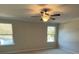 Spacious bedroom featuring a ceiling fan and natural light from two windows at 1406 Lucan Nw Ln # Wc221, Lawrenceville, GA 30043