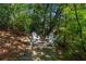 Secluded backyard fire pit area encircled with four white Adirondack chairs offering a relaxing retreat at 2517 Birchwood Ne Dr, Atlanta, GA 30305
