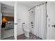 The bathroom features a toilet and shower combination with a white curtain, with bedroom in the background at 2535 Hampton Trl, Cumming, GA 30041