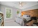 This bedroom features a wood accent wall, neutral paint, carpet flooring, and natural light at 2535 Hampton Trl, Cumming, GA 30041