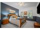 Comfortable bedroom featuring wood accent wall, soft carpet, a ceiling fan, and large windows at 2535 Hampton Trl, Cumming, GA 30041