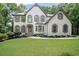Charming two-story home with a manicured lawn and inviting curb appeal surrounded by lush greenery at 2535 Hampton Trl, Cumming, GA 30041