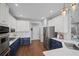 Charming kitchen featuring white cabinets, blue island, stainless steel appliances, and hardwood floors at 2535 Hampton Trl, Cumming, GA 30041