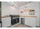 A well-equipped outdoor kitchen boasts a built-in grill, mini fridge, white cabinets, and ample countertop space for entertaining at 2535 Hampton Trl, Cumming, GA 30041