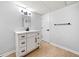 Bathroom with white vanity, modern fixtures, wood-look floors, and white walls at 3078 Milford Chase Sw, Marietta, GA 30008