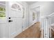 Inviting foyer with wood-look flooring, crisp white trim and staircase, and a charming, decorative front door at 3078 Milford Chase Sw, Marietta, GA 30008