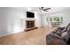 Open-concept living area with a brick fireplace, hardwood floors, and a view into the sunlit dining area at 3078 Milford Chase Sw, Marietta, GA 30008