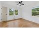 Bright bedroom with hardwood floors and two windows offering a view of the lush greenery outside at 3779 Elkridge Dr, Decatur, GA 30032