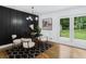 Elegant dining room with a black accent wall, stylish light fixture, and backyard views at 3779 Elkridge Dr, Decatur, GA 30032