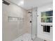 Modern walk-in shower featuring glass doors, neutral tile, and contemporary fixtures at 3779 Elkridge Dr, Decatur, GA 30032
