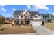 Charming two-story home with red shutters, manicured lawn, and a two-car garage at 2430 Redbud Meadow Ln, Douglasville, GA 30135
