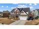 Charming two-story home with a well-maintained lawn, inviting front porch, and attached two-car garage at 2430 Redbud Meadow Ln, Douglasville, GA 30135