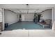 A two car garage with painted floors and walls, shelving, and storage is accessed by an electric garage door at 2430 Redbud Meadow Ln, Douglasville, GA 30135