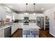 Well-lit kitchen with stainless steel appliances, white cabinets, and an island at 2430 Redbud Meadow Ln, Douglasville, GA 30135