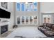 Bright, open living room with fireplace, high ceilings, large windows, and a leather sofa at 2430 Redbud Meadow Ln, Douglasville, GA 30135
